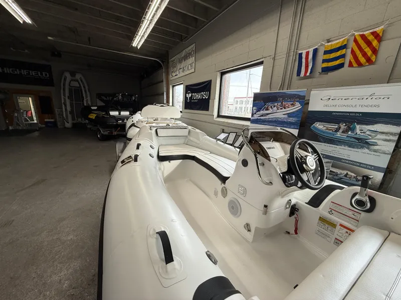 Slide: The Image of 2025 Walker Bay Generation 450 DLX boat displayed in a showroom with nautical flags. - 17