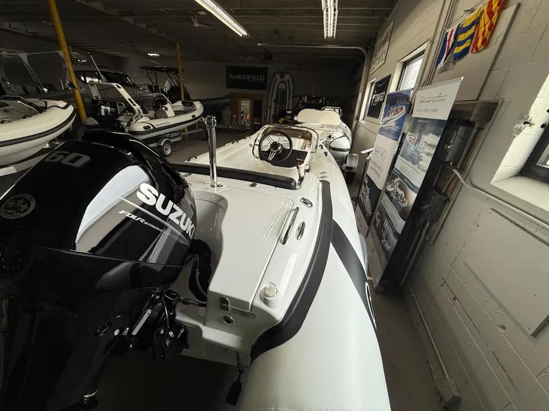 Slide: The Image of 2025 Walker Bay Generation 450 DLX boat with Suzuki engine in showroom. - 2