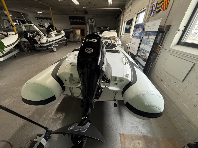 Slide: The Image of 2025 Walker Bay Generation 450 DLX boat in showroom, rear view with outboard motor. - 5