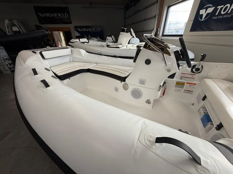 Slide: The Image of 2025 Walker Bay Generation 450 DLX inflatable boat interior, featuring white seating and steering console. - 8
