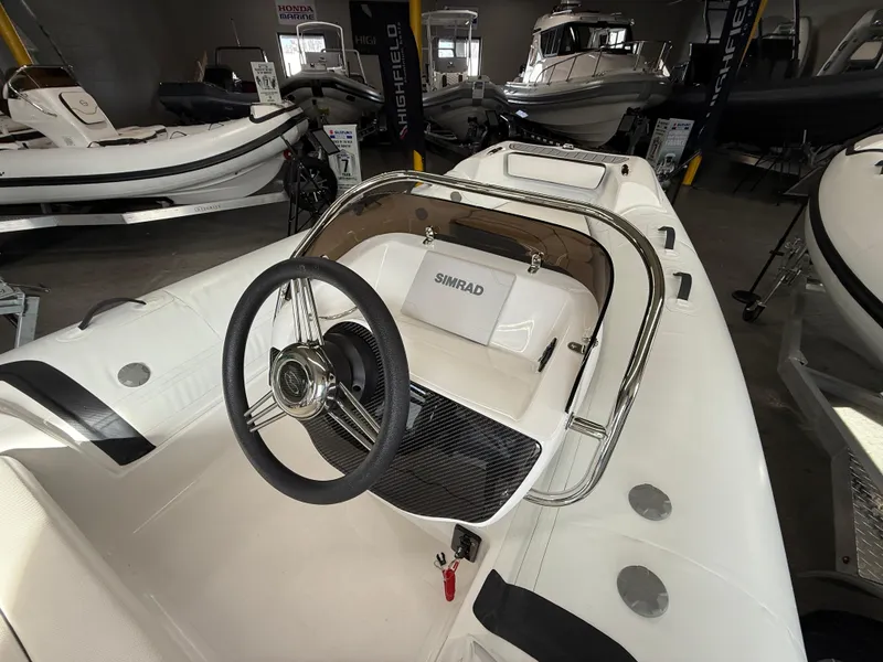 Slide: The Image of 2025 Walker Bay Generation 450 DLX boat interior with steering wheel and Simrad display. - 9