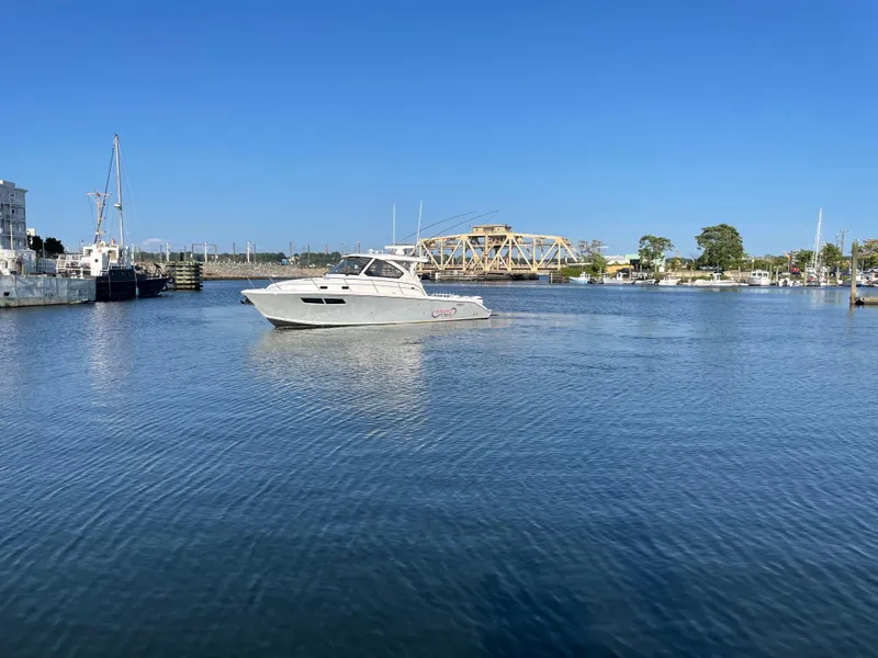 Slide: The Image of 2019 Pursuit OS 355 Offshore boat on calm water with clear blue sky. - 2