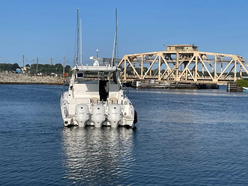 Slide: The Image of 2019 Pursuit OS 355 Offshore boat on water near a bridge. - 4