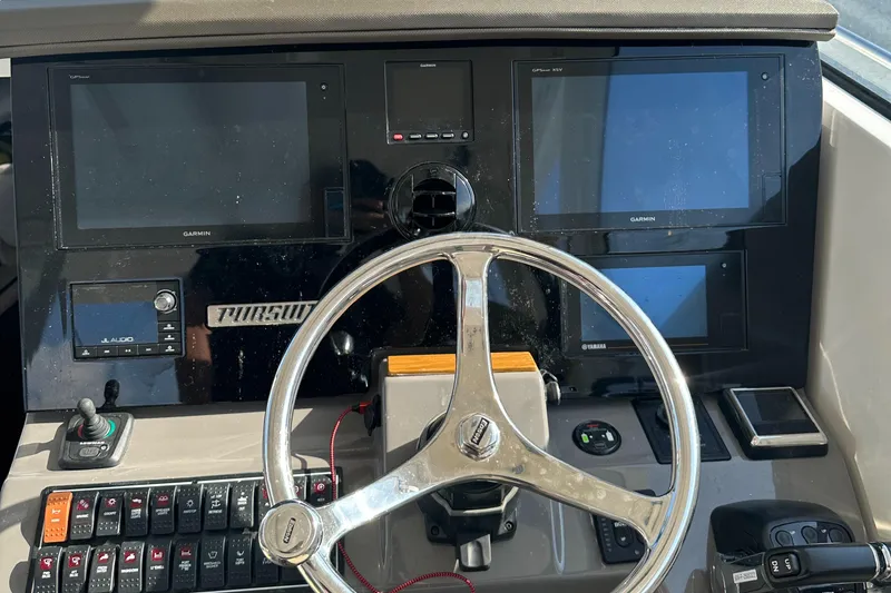 Slide: The Image of 2019 Pursuit OS 355 Offshore boat dashboard with steering wheel and electronic displays. - 7