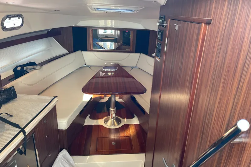 Slide: The Image of 2019 Pursuit OS 355 Offshore cabin with wood interior and seating area. - 8