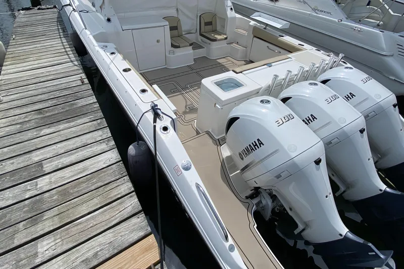 Slide: The Image of 2019 Pursuit OS 355 Offshore boat with triple Yamaha engines docked. - 9