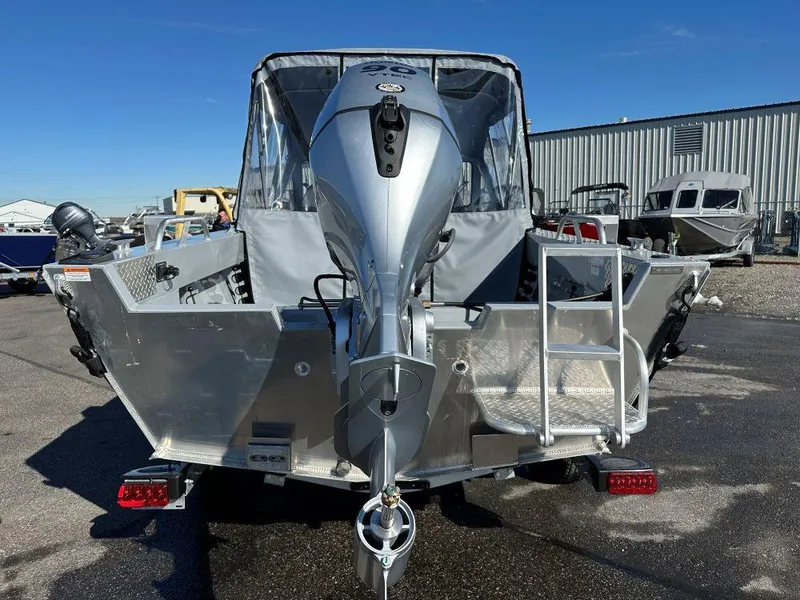 Slide: The Image of 2025 Hewescraft 180 Sportsman boat with outboard motor, rear view in a marina setting. - 4
