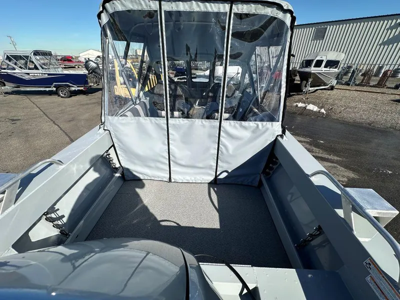 Slide: The Image of 2025 Hewescraft 180 Sportsman boat with covered seating area, parked outdoors. - 5