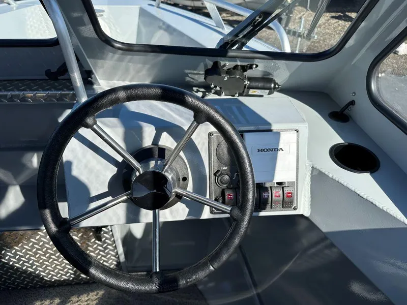 Slide: The Image of 2025 Hewescraft 180 Sportsman boat dashboard with steering wheel and Honda controls. - 7