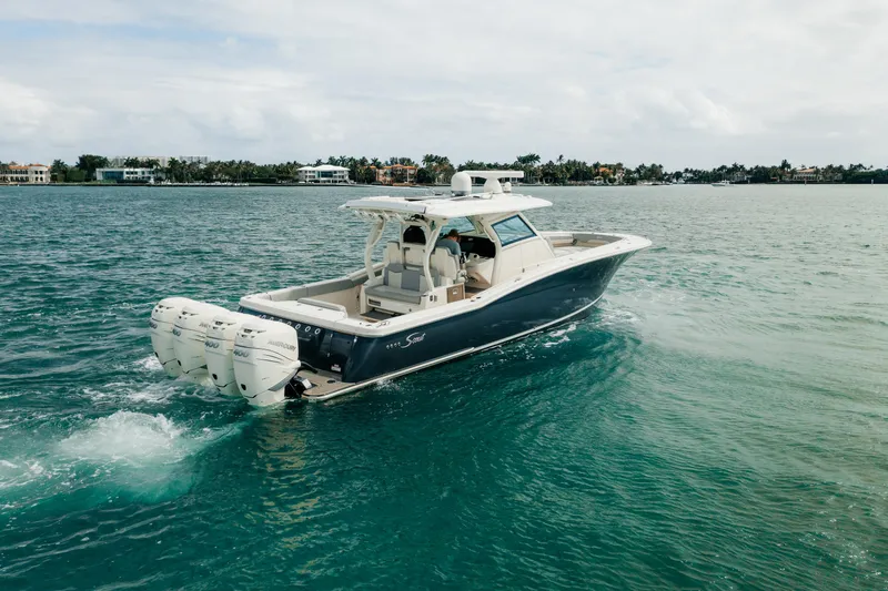 Slide: The Image of 2021 Scout 380 LXF boat cruising on clear blue water. - 2