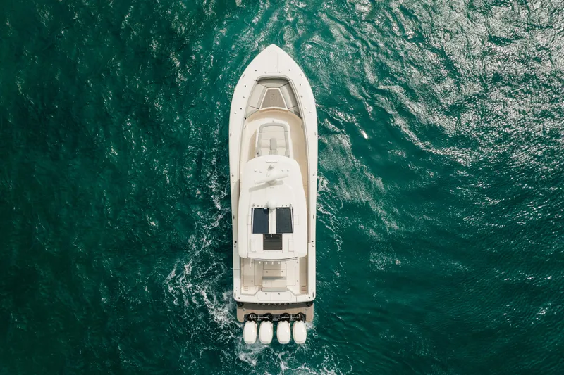 Slide: The Image of Aerial view of 2021 Scout 380 LXF boat cruising on turquoise water. - 4