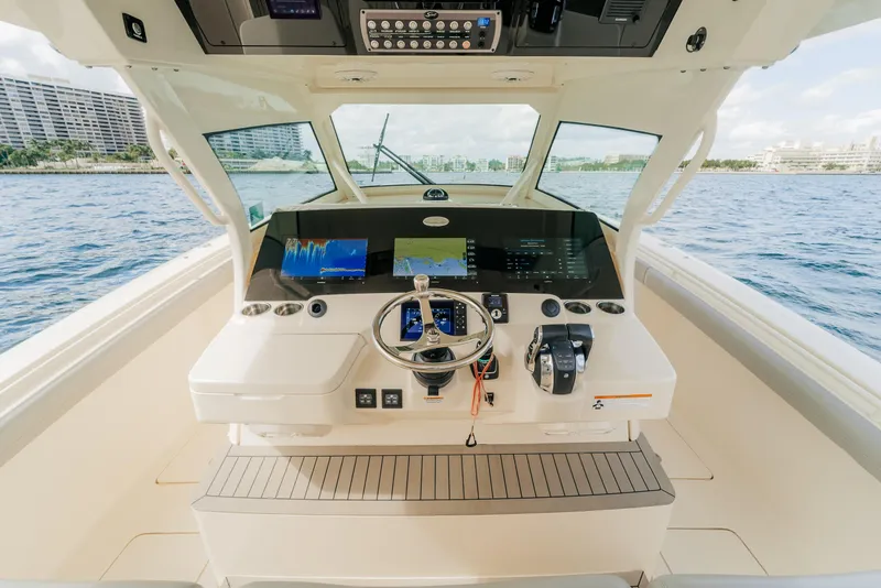 Slide: The Image of 2021 Scout 380 LXF boat helm with advanced navigation system on open water. - 8