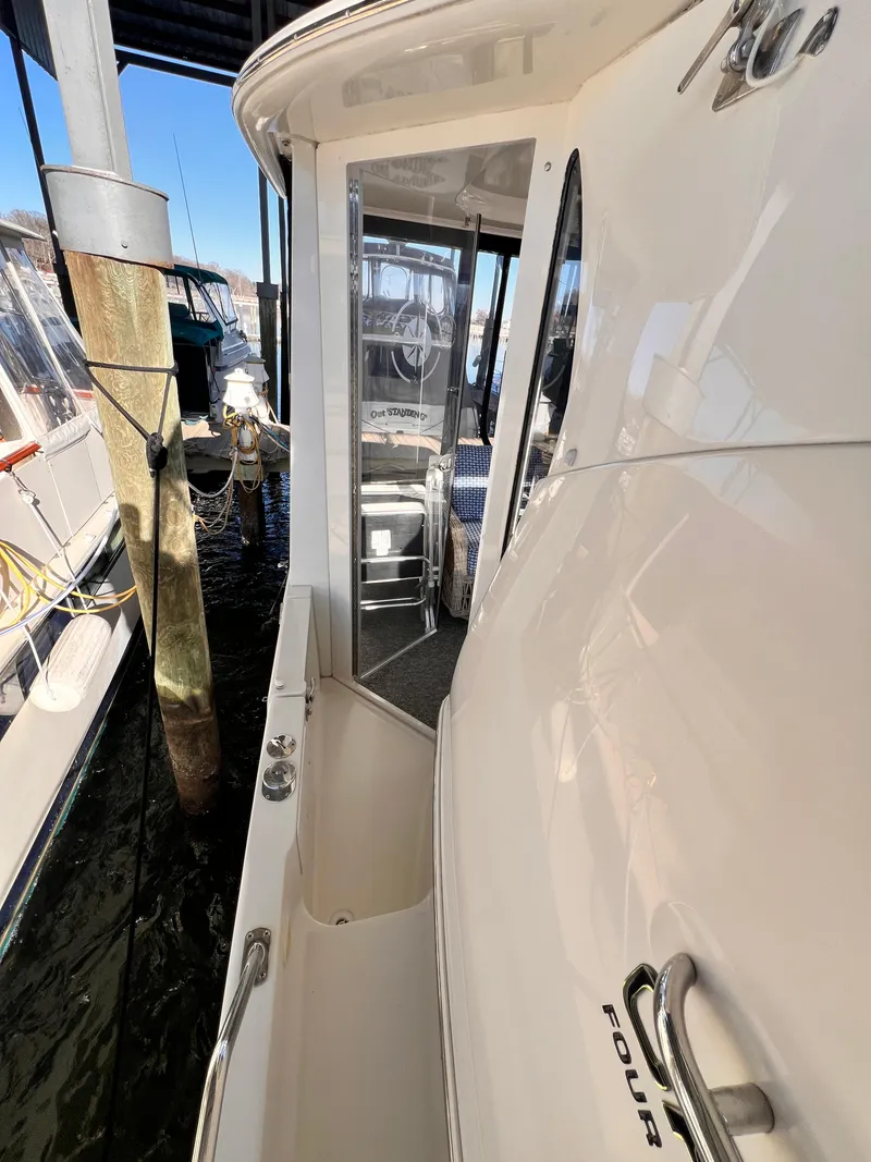 Slide: The Image of 2005 Carver 444 Cockpit Motor Yacht docked, showing side walkway and entrance. - 11