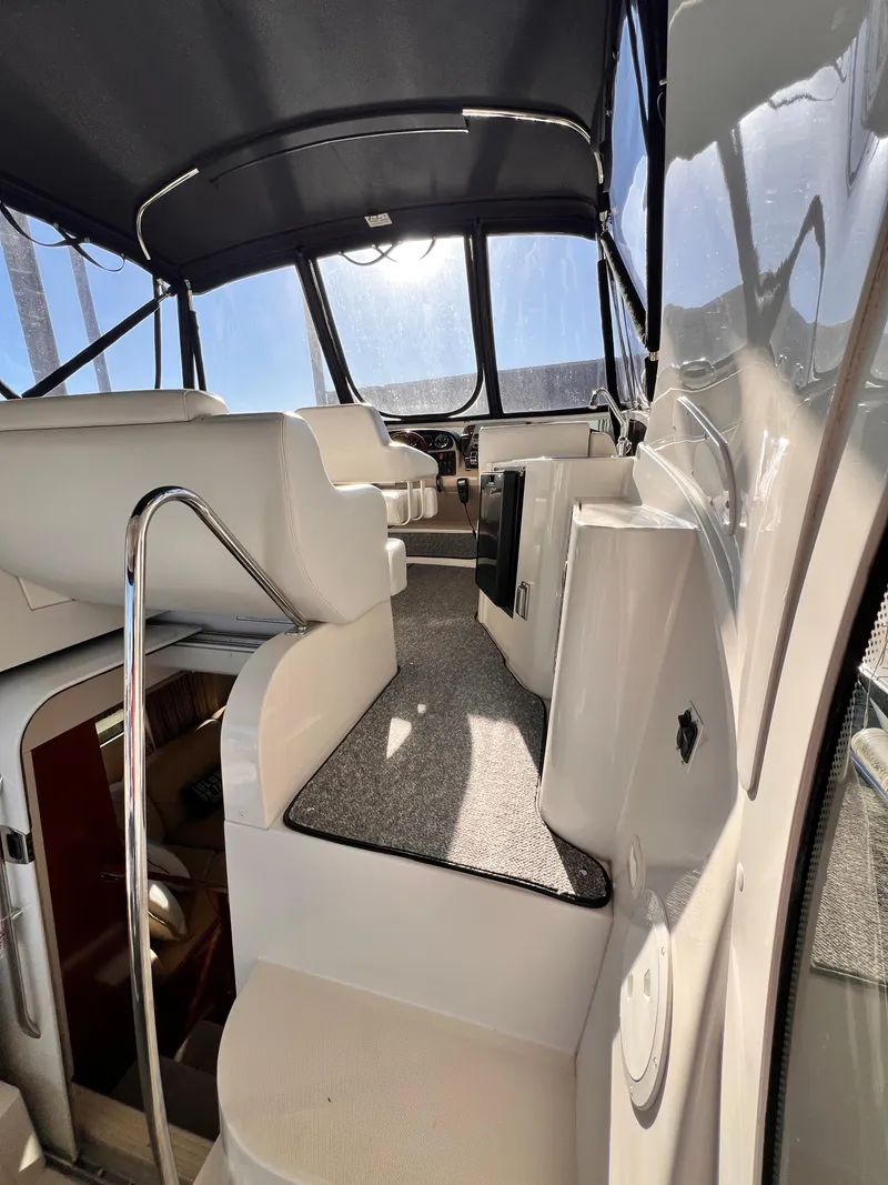 Slide: The Image of 2005 Carver 444 Cockpit Motor Yacht interior with seating and helm, under a canopy. - 14
