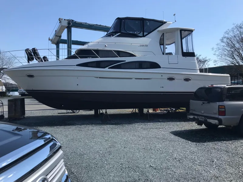 Slide: The Image of 2005 Carver 444 Cockpit Motor Yacht on display in a boatyard. - 2