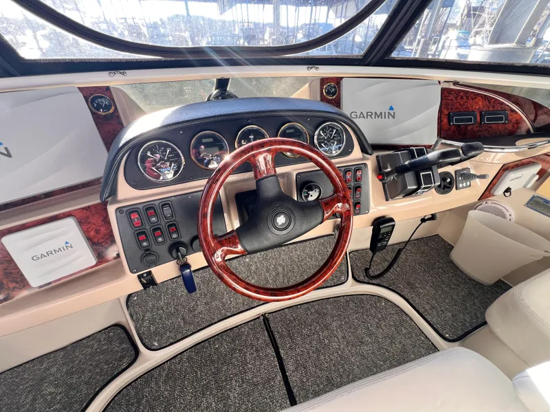 Slide: The Image of 2005 Carver 444 Cockpit Motor Yacht helm with Garmin navigation and wood-accented steering wheel. - 23