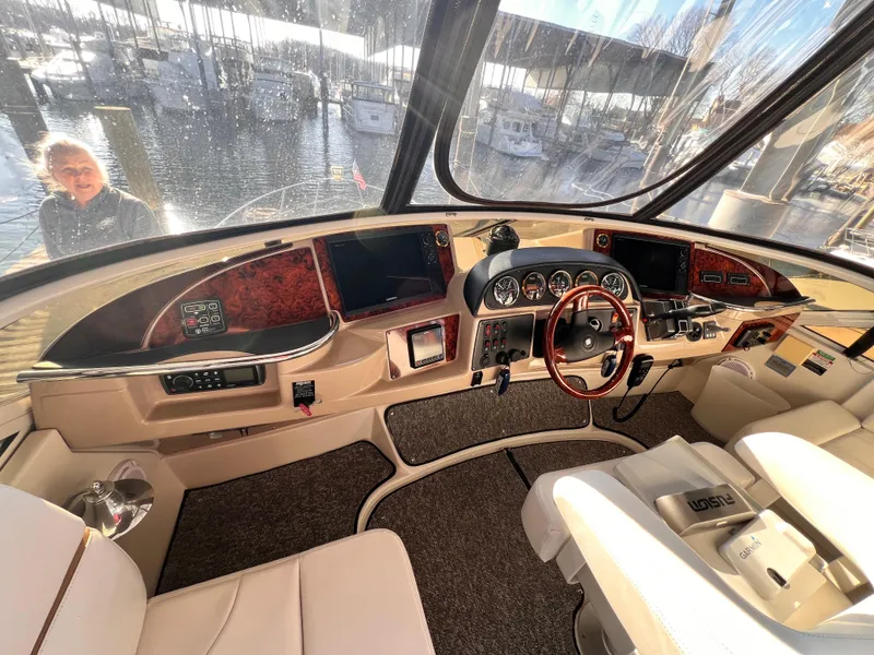 Slide: The Image of 2005 Carver 444 Cockpit Motor Yacht helm with modern controls and panoramic marina view. - 25