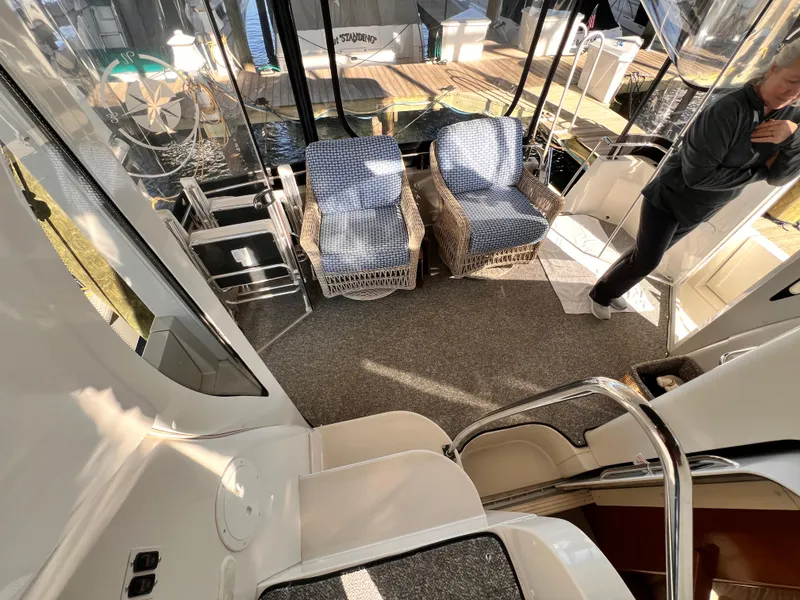 Slide: The Image of 2005 Carver 444 Cockpit Motor Yacht interior with wicker chairs and carpeted flooring. - 31