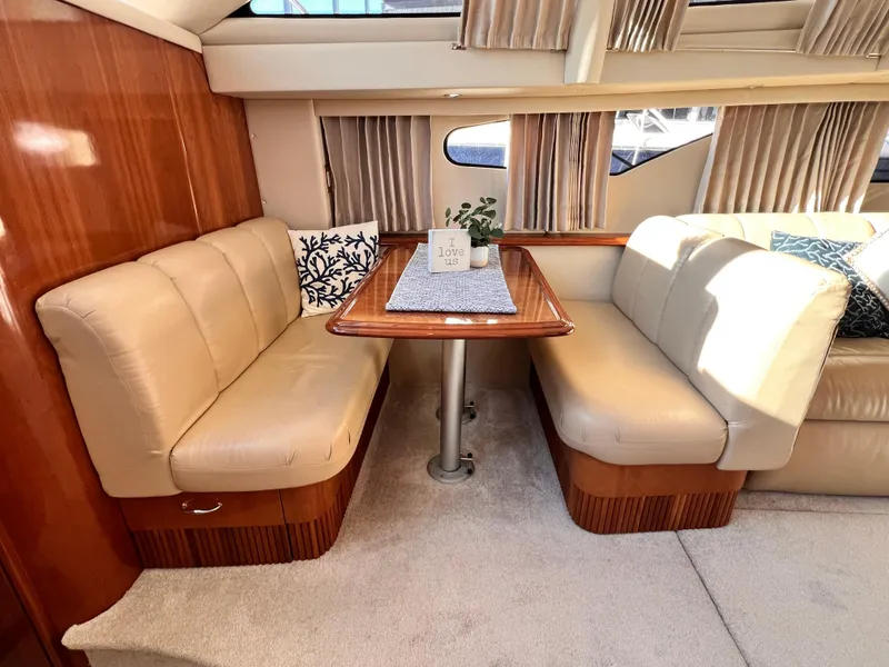 Slide: The Image of Luxurious interior of 2005 Carver 444 Cockpit Motor Yacht with beige seating and wooden table. - 36