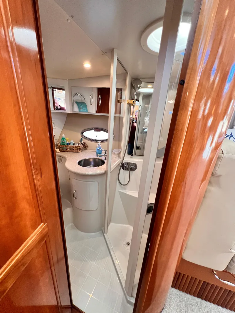 Slide: The Image of 2005 Carver 444 Cockpit Motor Yacht bathroom with sink, shower, and wooden cabinetry. - 41