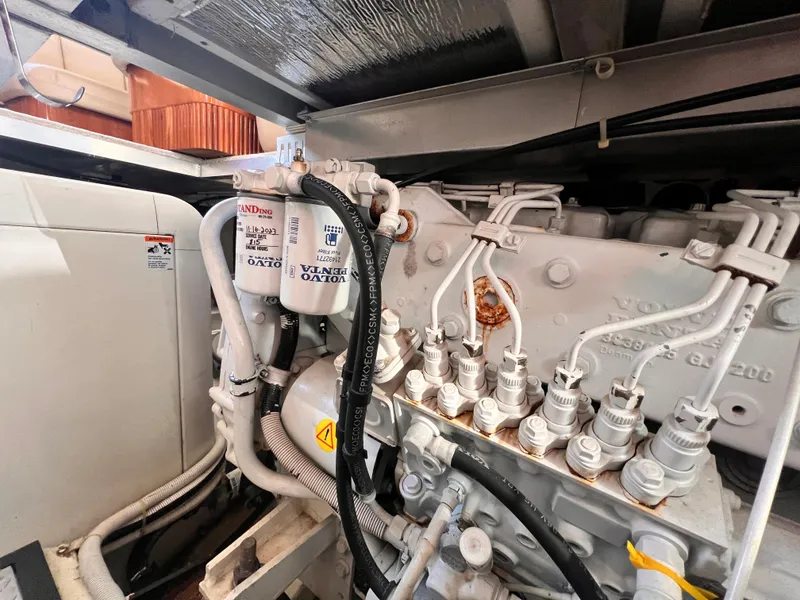 Slide: The Image of Engine compartment of a 2005 Carver 444 Cockpit Motor Yacht, featuring Volvo Penta components. - 52