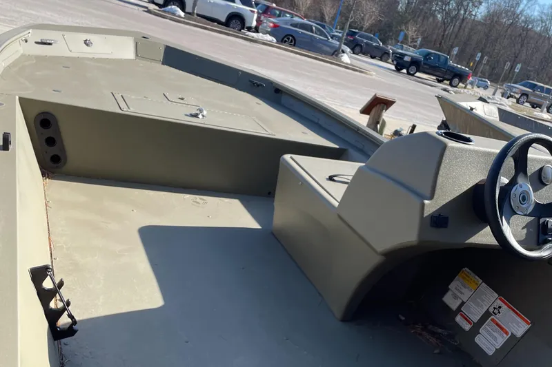 Slide: The Image of 2023 Tracker Grizzly 1754 boat interior with steering wheel, parked in a lot. - 5
