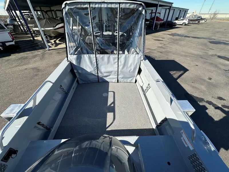 Slide: The Image of 2025 Hewescraft 200 Sportsman boat with covered seating area, parked outdoors. - 4