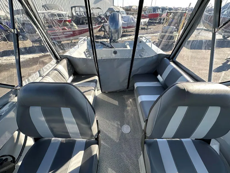 Slide: The Image of 2025 Hewescraft 200 Sportsman boat interior with striped seating and steering console. - 7