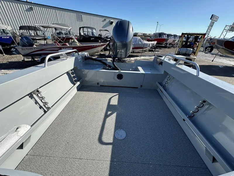 Slide: The Image of 2025 Hewescraft 200 Sportsman boat interior with motor, parked outdoors. - 8