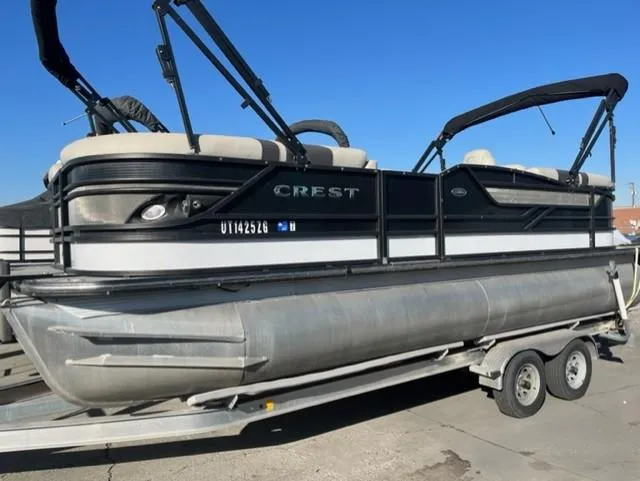 Slide: The Image of 2019 Crest 230 SLC pontoon boat on trailer under clear blue sky. - 0
