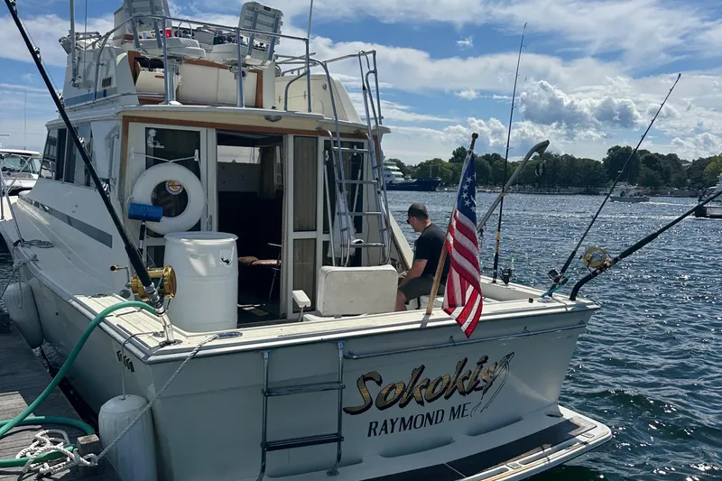 Slide: The Image of 1978 Viking Boats 35 docked, featuring fishing gear and American flag, on a sunny day. - 5