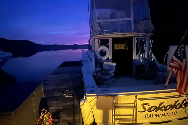 Slide: The Image of 1978 Viking Boats 35 docked at sunset with American flag, serene water view. - 6