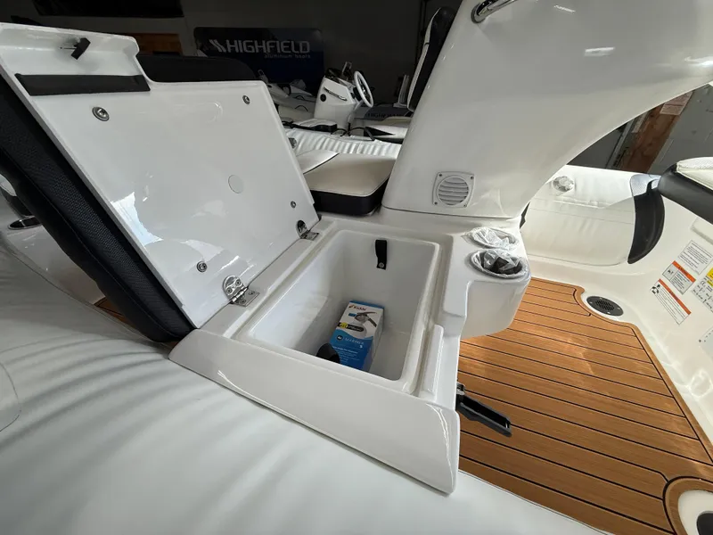 Slide: The Image of 2025 Walker Bay Generation 14 LTE boat interior with open storage compartment and wooden deck. - 9