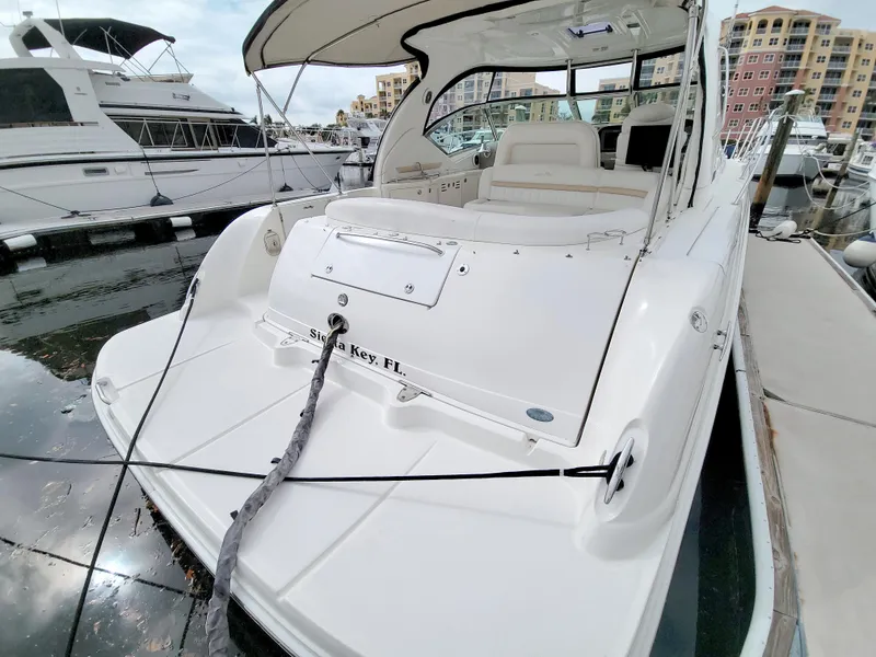 Slide: The Image of 2009 Sea Ray 44 Sundancer yacht docked at marina, showcasing spacious deck and sleek design. - 12