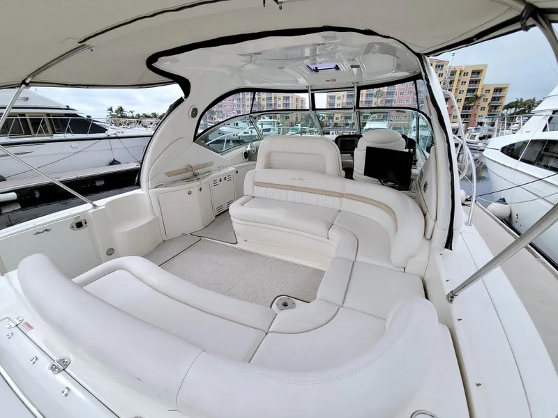 Slide: The Image of 2009 Sea Ray 44 Sundancer yacht interior with white seating and marina view. - 13