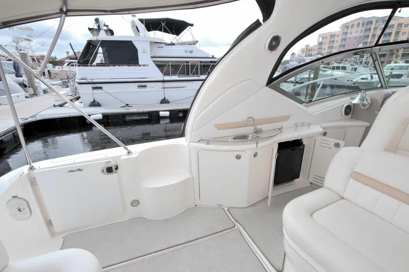 Slide: The Image of 2009 Sea Ray 44 Sundancer yacht interior with seating and kitchenette, docked at marina. - 15