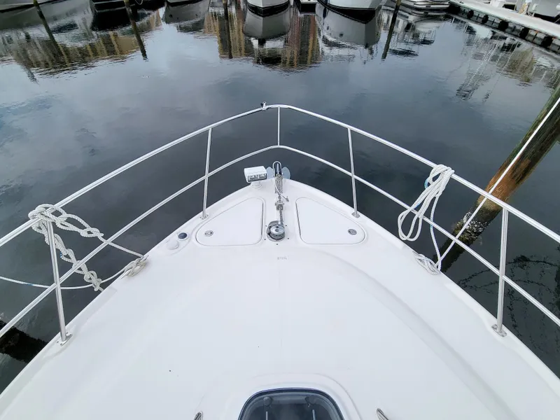 Slide: The Image of 2009 Sea Ray 44 Sundancer bow view at marina, calm water reflection. - 18