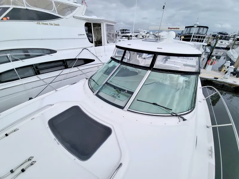 Slide: The Image of 2009 Sea Ray 44 Sundancer yacht docked at marina, showcasing sleek design and spacious deck. - 23