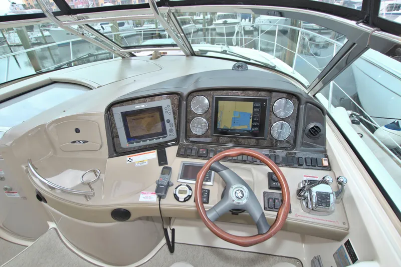 Slide: The Image of 2009 Sea Ray 44 Sundancer helm with navigation displays and steering wheel. - 29