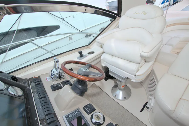 Slide: The Image of 2009 Sea Ray 44 Sundancer helm with luxurious white seating and wooden steering wheel. - 31