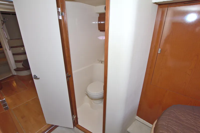 Slide: The Image of 2009 Sea Ray 44 Sundancer yacht bathroom interior with wooden cabinetry and white fixtures. - 40