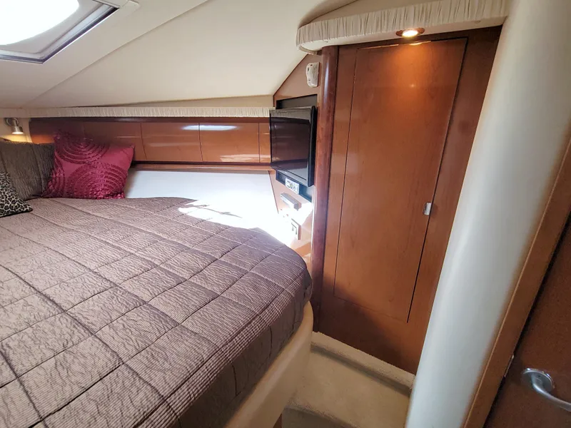 Slide: The Image of 2009 Sea Ray 44 Sundancer cabin interior with bed, wooden cabinetry, and natural light. - 45