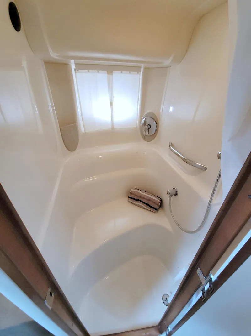 Slide: The Image of 2009 Sea Ray 44 Sundancer bathroom with shower, featuring sleek white interior design. - 48