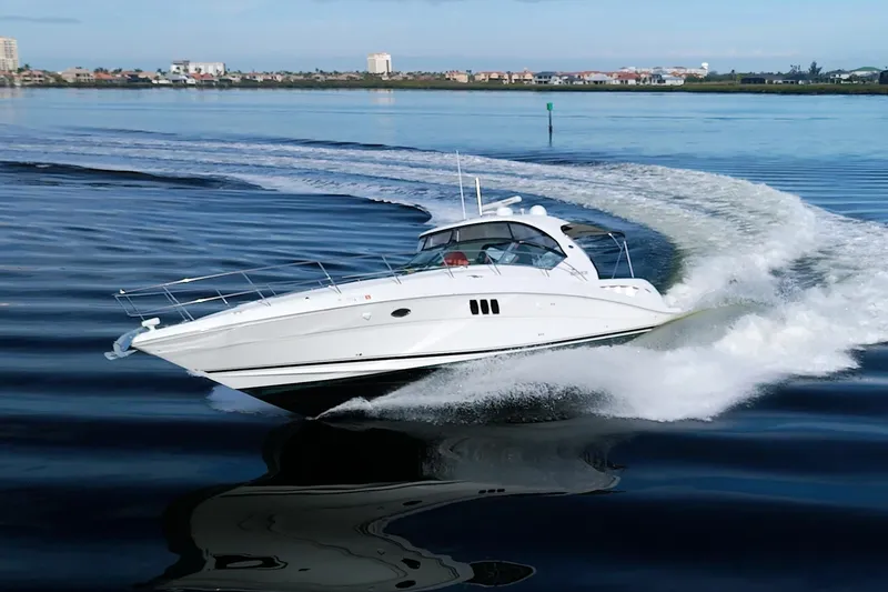 Slide: The Image of 2009 Sea Ray 44 Sundancer cruising on calm waters, creating a dynamic wake. - 6