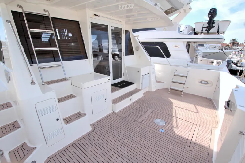 Slide: The Image of 1999 West Bay 58 Sonship yacht deck with seating and storage areas. - 15