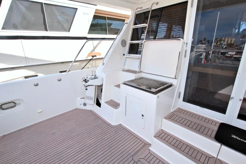 Slide: The Image of 1999 West Bay 58 Sonship yacht deck with grill and seating area. - 18