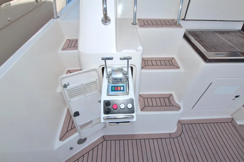 Slide: The Image of 1999 West Bay 58 Sonship yacht controls and steps, featuring teak flooring. - 19
