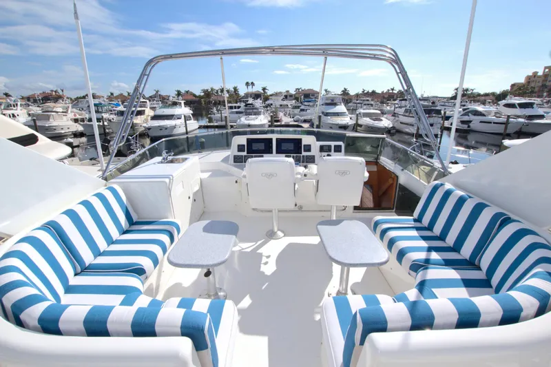 Slide: The Image of 1999 West Bay 58 Sonship yacht with striped seating in a marina setting. - 24