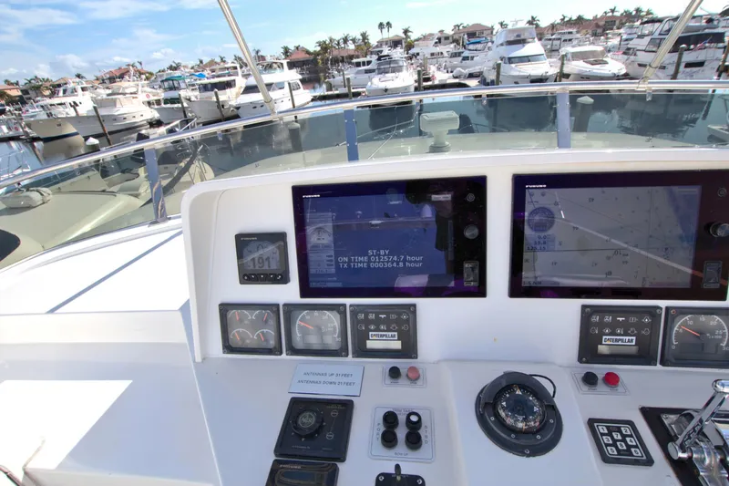 Slide: The Image of Cockpit view of 1999 West Bay 58 Sonship yacht with navigation screens and marina background. - 29
