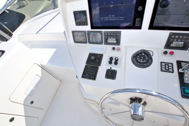 Slide: The Image of Control panel of a 1999 West Bay 58 Sonship yacht, featuring navigation instruments and steering wheel. - 30